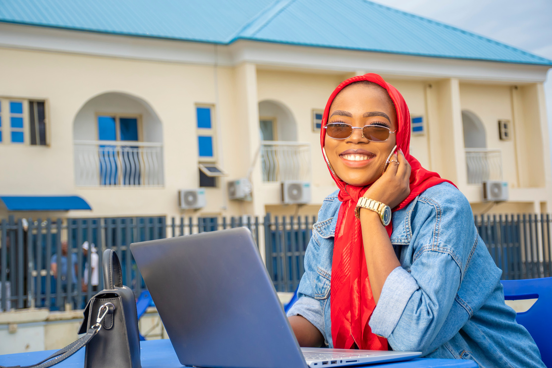 portrait of a pretty african lady using her laptop outdoor